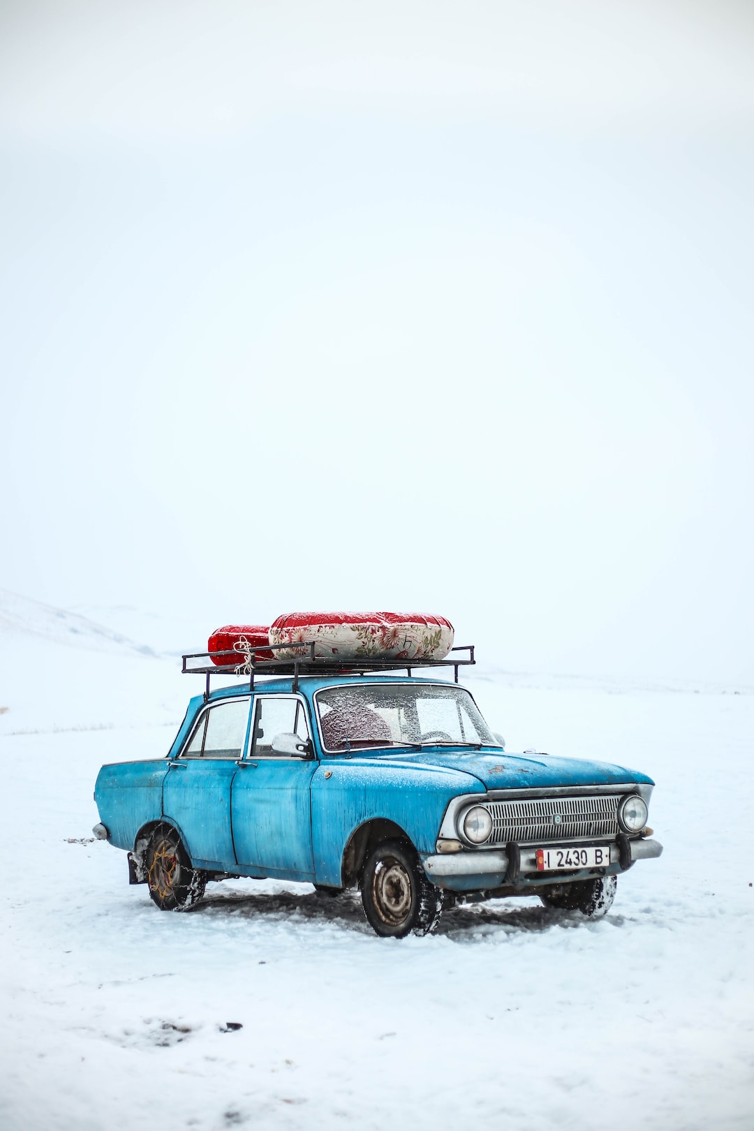 blue sedan on snow ground