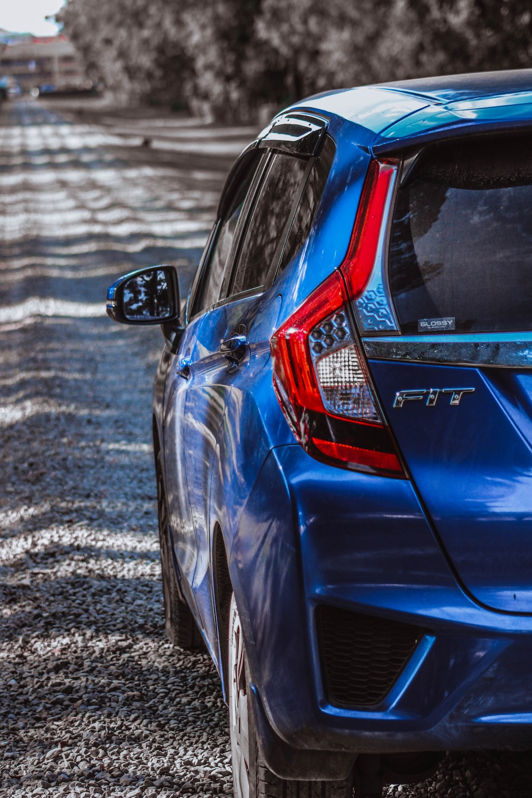 a blue car parked on a gravel road