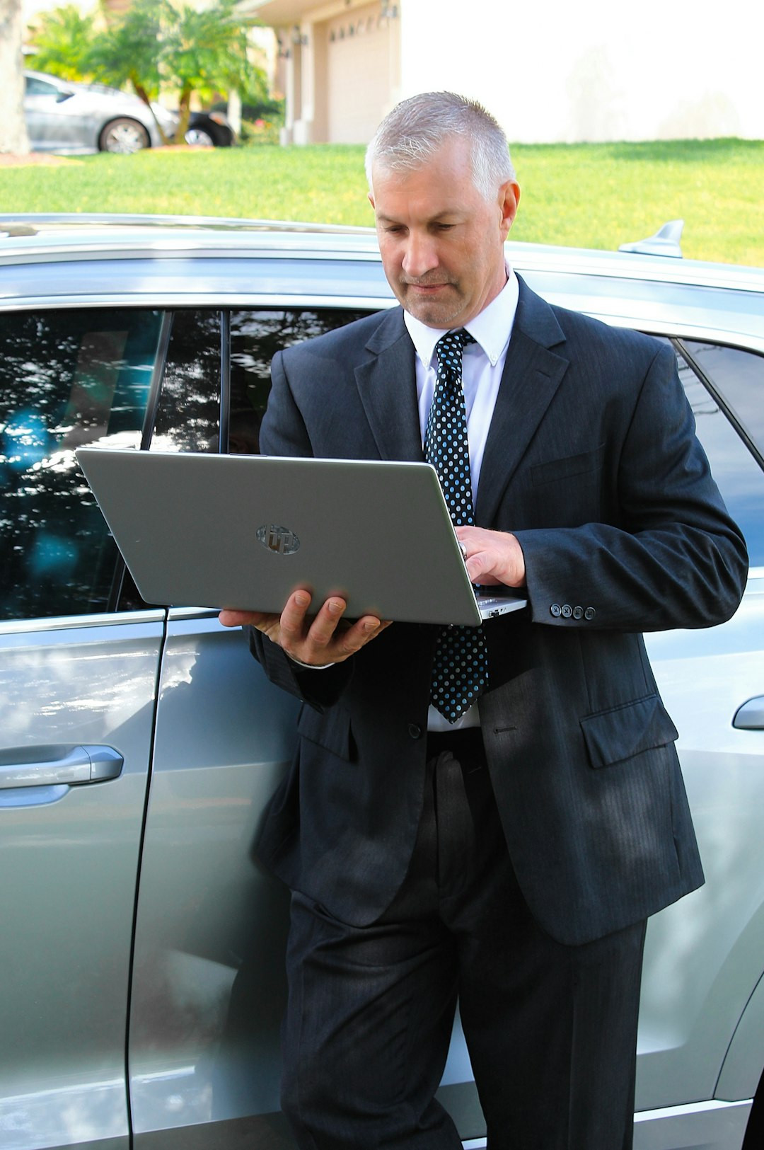 a man in a suit is looking at a laptop