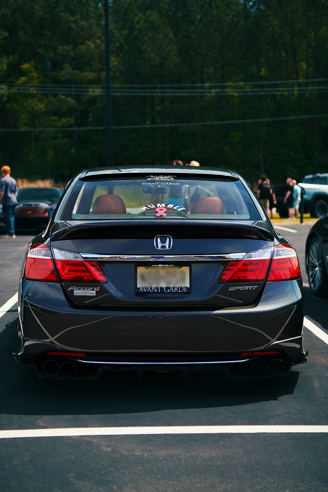A black honda accord sport parked on pavement.