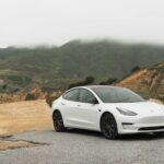 white sedan parked beside mountain during daytime